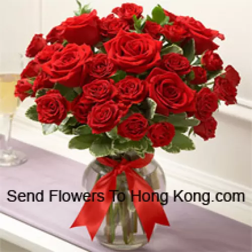 36 Roses rouges avec quelques fougères dans un vase en verre